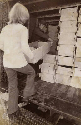 1974 photograph of Law Library. Students transport books to the new library.