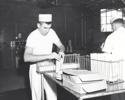 1960 photograph of Dairy Farm and Creamery. Two students package U of I ice cream. Donor: Photo Center.