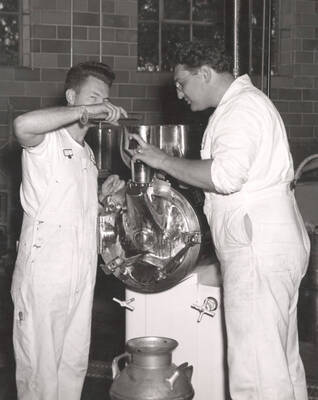 1953 photograph of Dairy Farm and Creamery. Students operate an ice cream machine. Donor: Publications Dept..