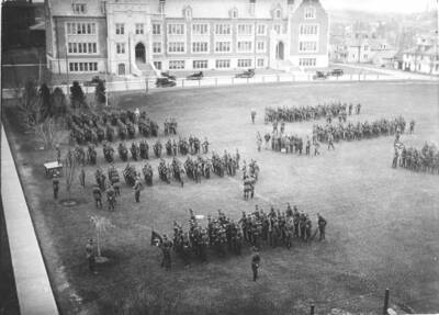 1926 photograph of Military Science Cadets. Cadets participating in military drill in front of Science building.