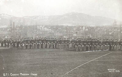 1919 photograph of Military Science Cadets. Military cadet battalion in formation on campus. Campus buildings in the background.