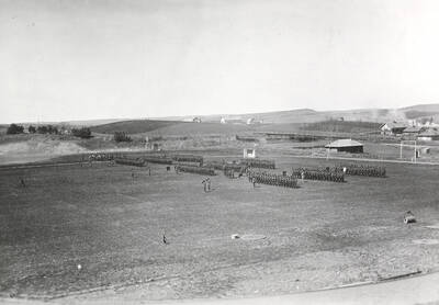 1926-04-15 photograph of Military Science Cadets. Military cadets on review at Maclean field. University farms are visible in the background.