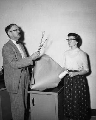1954 photograph of Plant Sciences. Dr. George W. Woodbury and Mrs. Wayne Crow prepare a Syringa plant. Donor: Publications Dept.