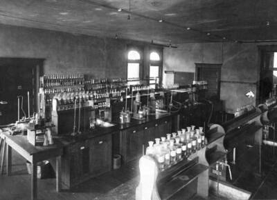 1907 photograph of Chemistry Class. Fully stocked lab tables in the Chemistry laboratory.
