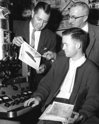 1961 photograph of Chemistry Class. J. Irving Jolley, Emmett E. Spiker, and Pete Kelly examine an electron microspore. Donor: Publications Dept.