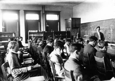 1938 photograph of Chemistry Class. Students sitting at desks during class.