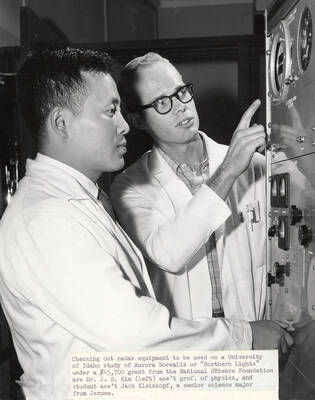 1960 photograph of Physics building. Professor and student check out the equipment.