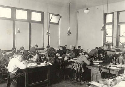 1936 photograph of Botany building. Students work with microscopes in the lab.