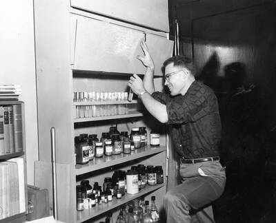 1961 photograph of Botany building. Don Fosket checks out supplies in the lab.