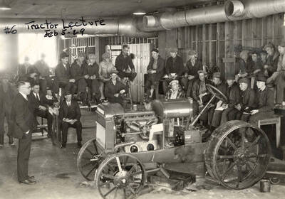 1929-02-05 photograph of Agricultural engineering building. Professor lectures students in the engineering shop.