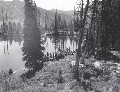 1966 photograph of College of Forestry. Students sitting on a hillside overlooking a lake during the forestry summer camp. Also print. Donor: Fred Johnson.
