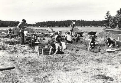 1970-07-03 photograph of College of Forestry. Students excavating test pits near a lake during the forestry summer camp. Donor: Fred Johnson.