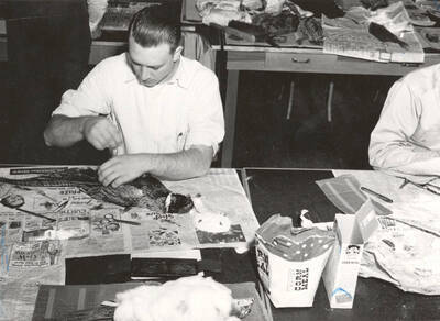 1950 photograph of College of Forestry. Bryce Beck studying a ring-necked pheasant. Donor: Publications Dept.