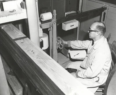 1960 photograph of College of Forestry. Arland D. Hofstrand using a machine to test beams. Donor: Publications Dept.