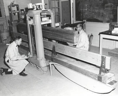 1961 photograph of College of Forestry. John P. Howe and Arland D. Hofstrand use a machine to test beams. Donor: Publications Dept.