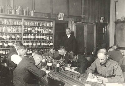 1923 photograph of College of Forestry. Students in the forestry laboratory under the direction of C. W. Watson.
