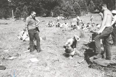 1963 photograph of College of Forestry. Students work in a field during the forestry summer camp. Also print. Donor: Fred Johnson.