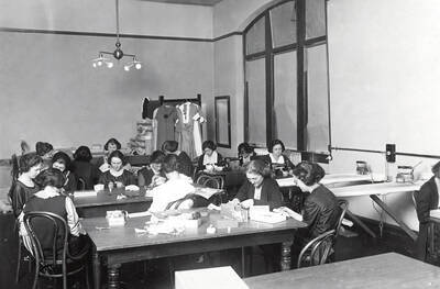 1927 photograph of Home Economics. Students sewing during class.