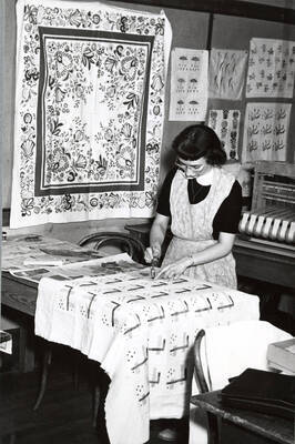 1945 photograph of Home Economics. A student works in the textiles laboratory.