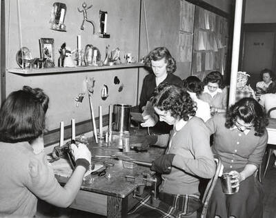 1942 photograph of Home Economics. Students Dorothy Wiley, Julein Paulson, Erma Smith, and Florence Marshall during tinwork class.