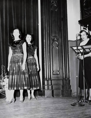 1942 photograph of Home Economics. Yvonne George, Adrienne George modeling dresses during a fashion show.