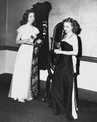 1945 photograph of Home Economics. Two students modeling dresses at a fashion show.