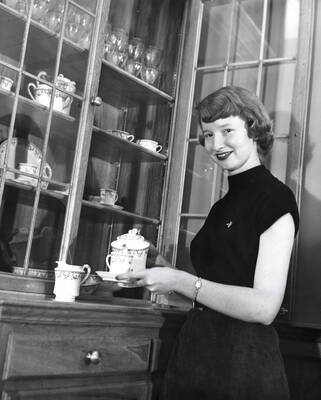 1954 photograph of Home Economics. Patricia Stewart demonstrates tea pouring. Donor: Publications Dept.