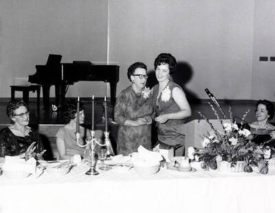 1965 photograph of Home Economics. Margaret Ritchie, retiring professor of Home Economics and Darlene Dougherty, past president of Home Economics Club. Donor: Publications Dept.