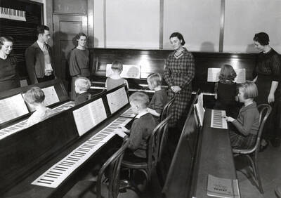 1937 photograph of Music Department. Children practice reading music during a summer music class.