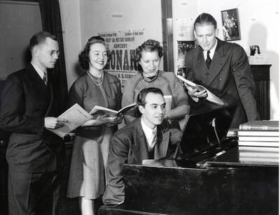 1940 photograph of Music Department. A.A. Becker rehearses at a piano