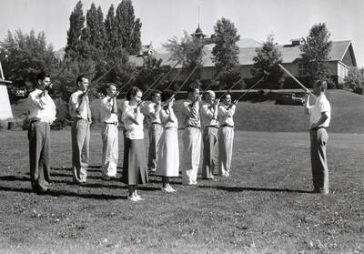 1934 photograph of Music Department. Student marching band practices conducting during summer music class.