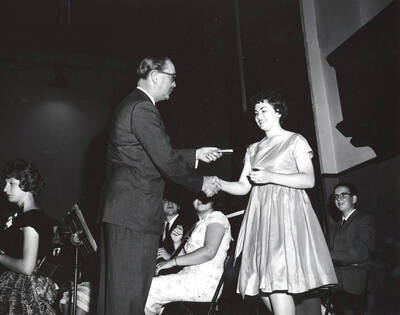 1951 photograph of Music Department. Hall Macklin presenting a summer music camp award to Ann Williams. Donor: Publications Dept.