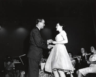 1951 photograph of Music Department. Hall Macklin presenting a summer music camp award to Camille Bastian. Donor: Publications Dept.
