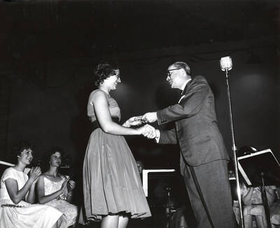 1951 photograph of Music Department. Hall Macklin presenting a summer music camp award to Kay Hostetler. Donor: Publications Dept.
