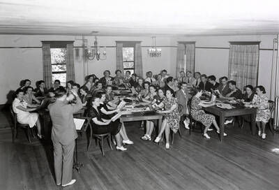 1938 photograph of Music Department. D. Sterling Wheelwright instructs a classroom of students.