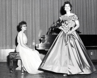 1962 photograph of Music Department. Linda Smith performing during a senior recital accompanied by Angela Sherbenou. Donor: Publications Dept.