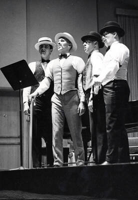 1961 photograph of Music Department. Barbershop quartet Pat Freeman, John Pederson, Larry Gee, and Alan Hamilton performing. Donor: Publications Dept.