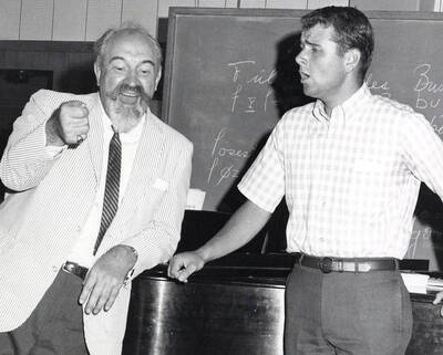 1956 photograph of Music Department. A student takes part in a vocal lesson. Donor: Publications Dept.