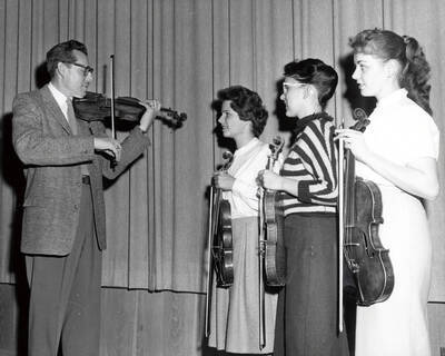 1961 photograph of Music Department. LeRoy Bauer with violin students. Donor: Publications Dept.