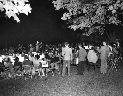 1945 photograph of Music Department. Summer school band performs during a night concert.