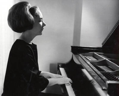 1963 photograph of Music Department. Paula Tyler playing a piano. Donor: Publications Dept.