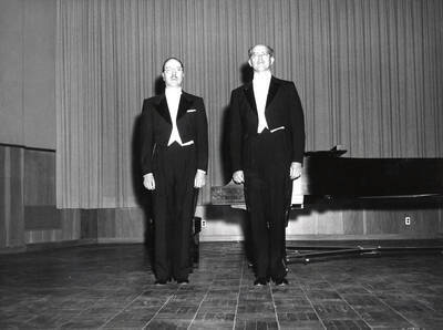 1962 photograph of Music Department. Hall Macklin and Norman R. Logan on stage in front of a piano.