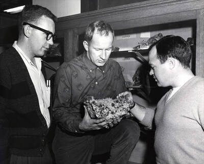 1959 photograph of College of Mines. Students examining an ore specimen.