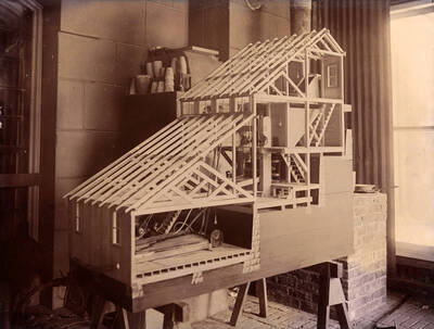 1899 photograph of College of Mines. A small model of the stamp and concentrate mill.