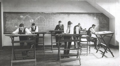 1926 photograph of College of Engineering. Students drawing at drafting desks during class.