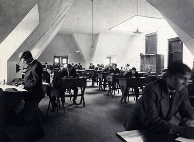 1907 photograph of College of Engineering. Students at drafting desks during class.