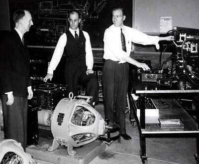 1942 photograph of College of Engineering. J. Hugo Johnson, Keith Freeman, and David C. Stevens in the electrical engineering laboratory.