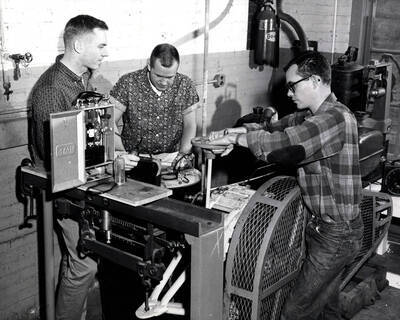 1962 photograph of College of Engineering. Dean Kohntopp, Ralph Brown, Allan Ross analyze exhaust gases in a laboratory. Donor: Publications Dept.