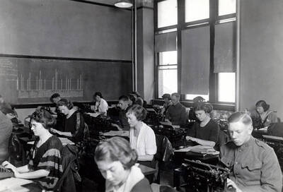 1929 photograph of College of Business Administration. Students on typewriters during class.