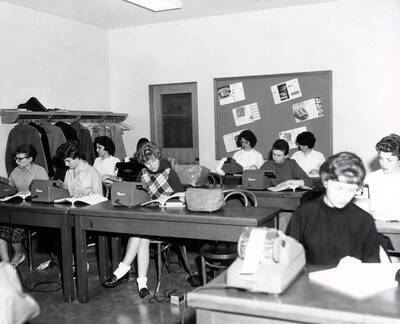 1961 photograph of College of Business Administration. Students studying office machines during class. Donor: Photo Center.
